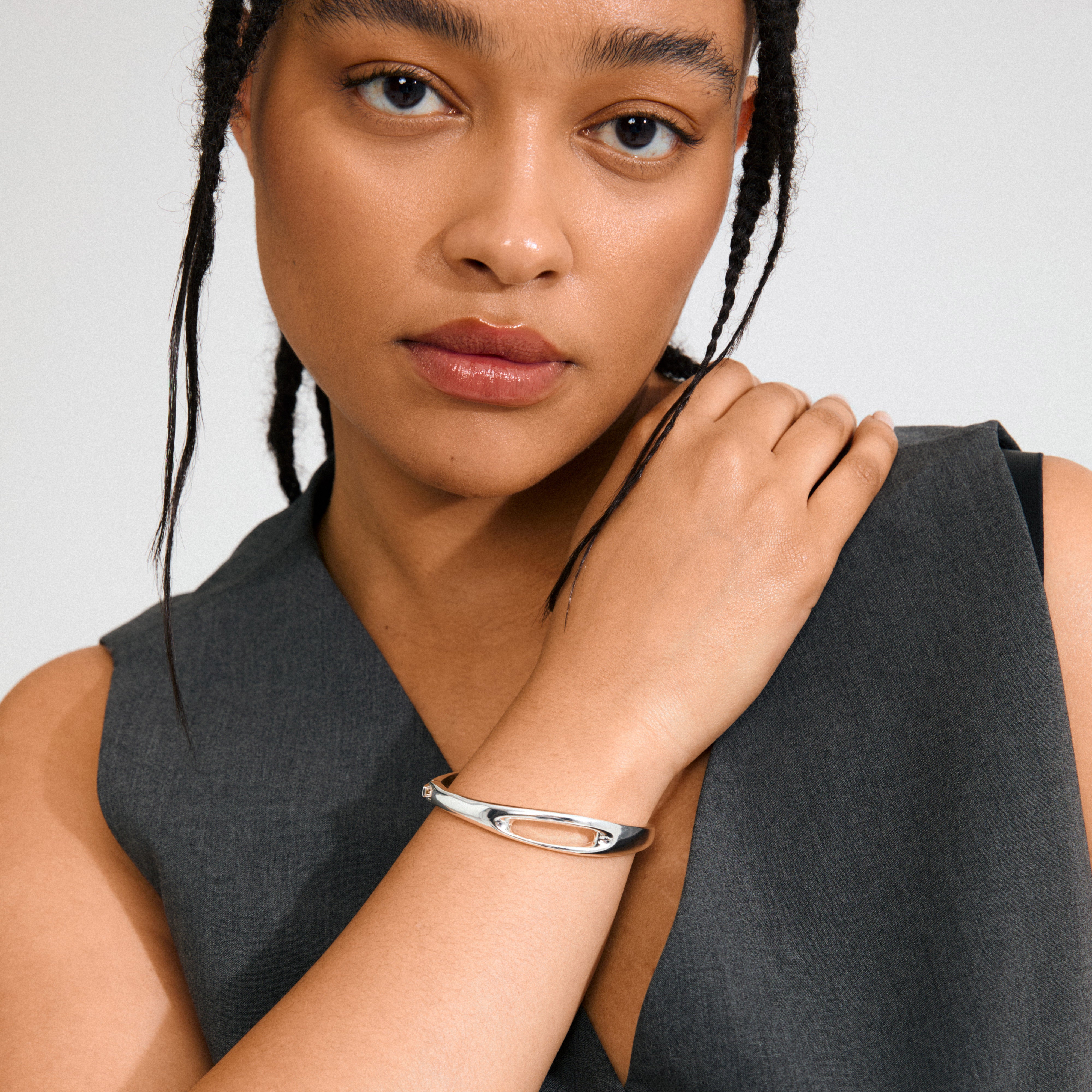 Young woman models Pilgrim's silver-plated FREE bangle, showcasing its minimalist sculptural open-oval design, embodying modern Scandinavian elegance.