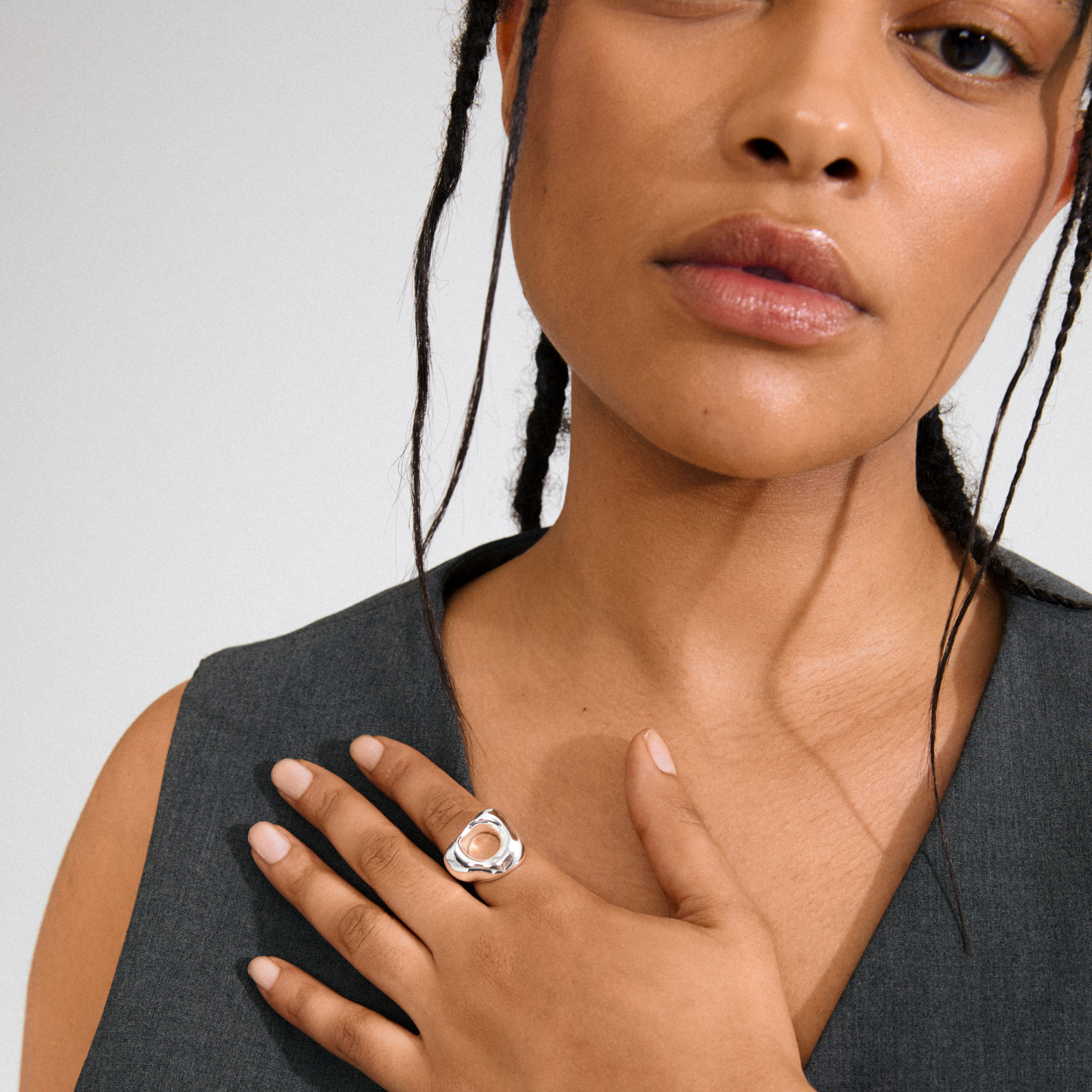 Young woman wearing Pilgrim's FREE ring silver-plated, a sculptural, organic-shaped statement piece on her ring finger, embodying modern elegance and eco-friendly craftsmanship.