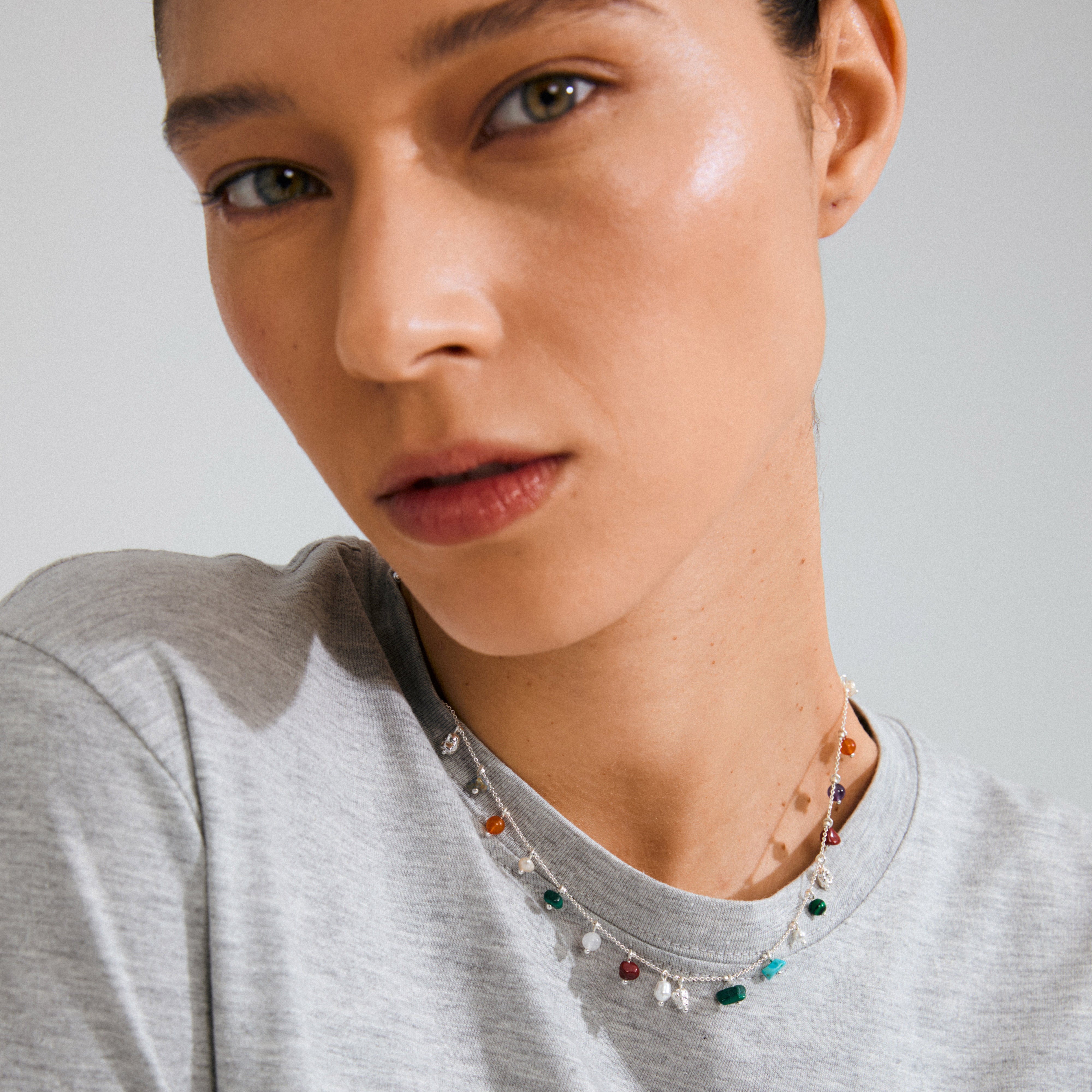 Close-up of a woman's neck wearing the silver-plated BETWEEN necklace by Pilgrim, featuring semi-precious stones for a luxe boho vibe.