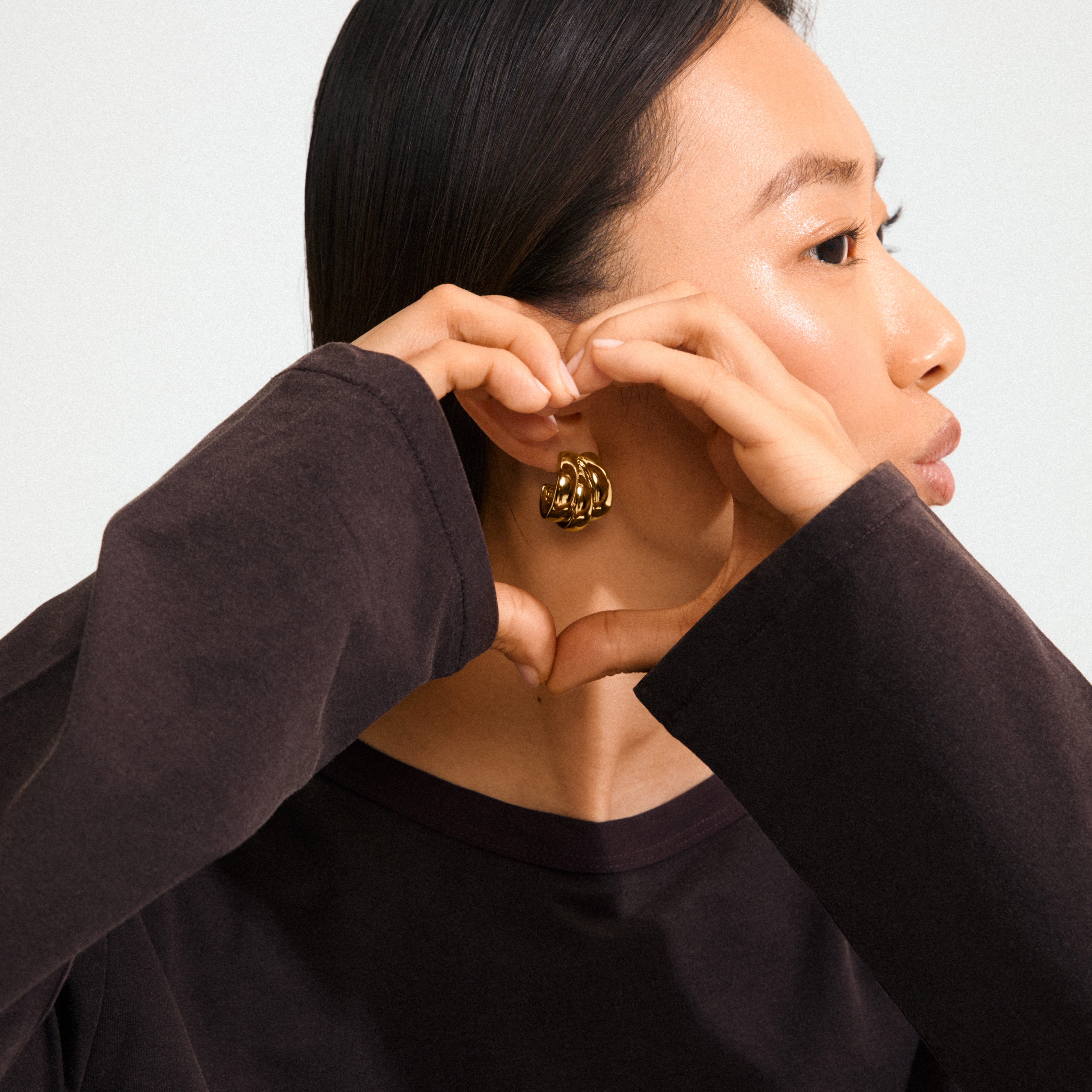 Person in profile showcasing Pilgrim’s gold-plated DAMIAN earrings, featuring a chunky, triple-ring design, perfect for adding a trendy, powerful statement to any look.