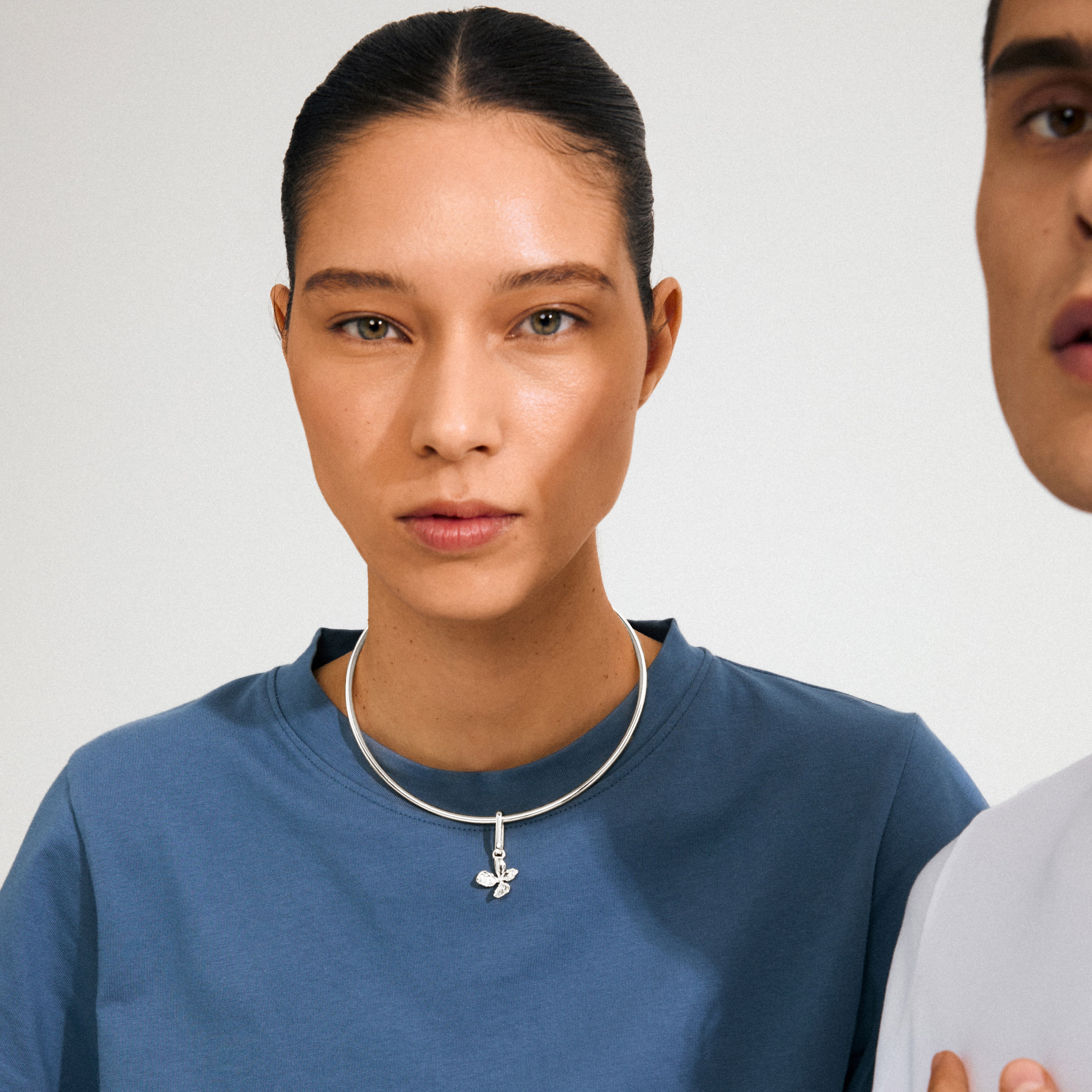 Young woman wearing Pilgrim's CHARM flower pendant, silver-plated, featuring a botanical-inspired charm on a chunky necklace, embodying a sweet boho vibe.