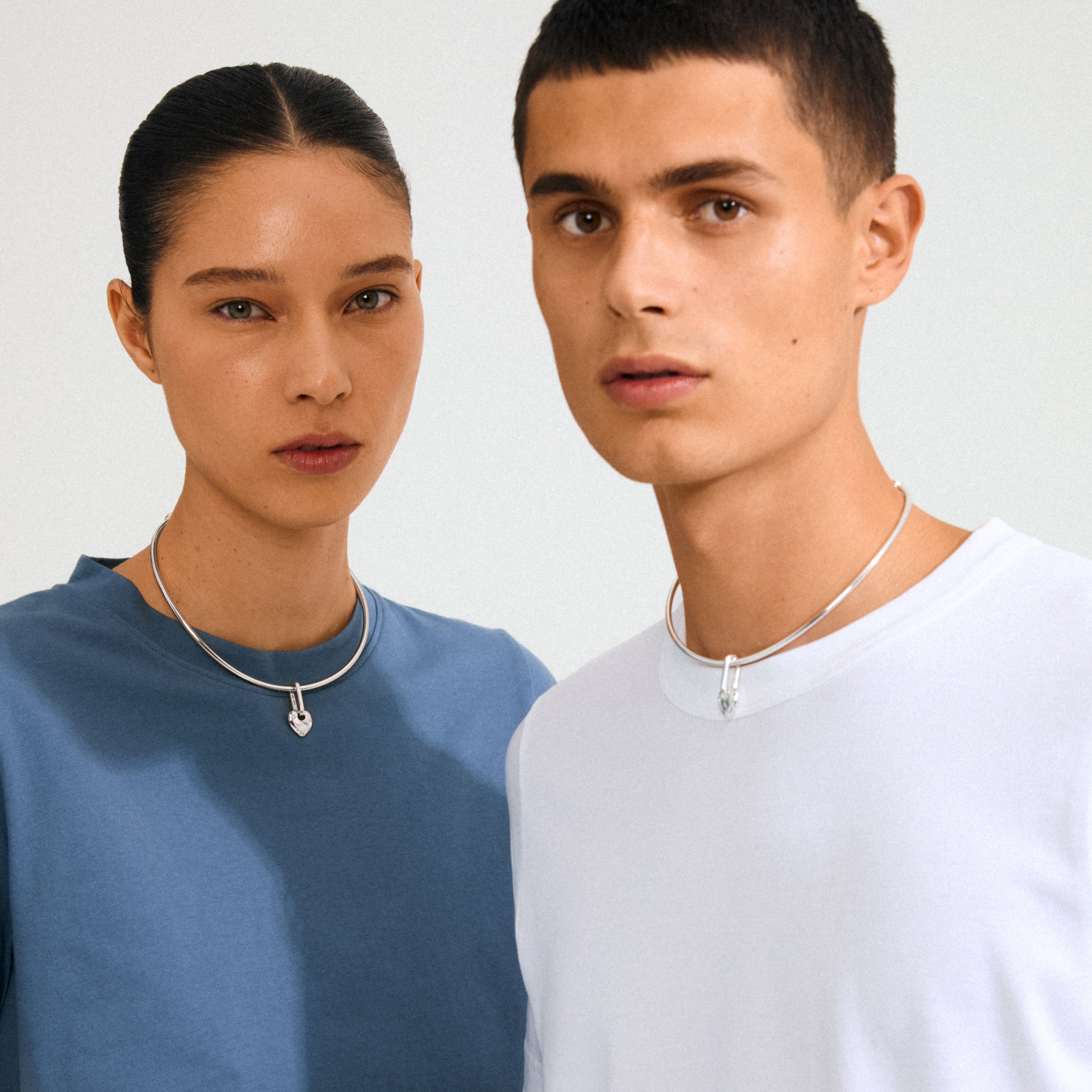 Models wear silver chokers with Pilgrim's CHARM rough heart pendant, silver-plated, highlighting minimalist style and individuality. A modern, elegant touch for personal expression.